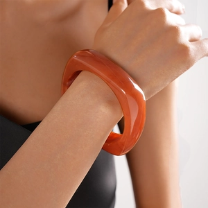 Close-up of translucent amber resin geometric bangle with polished glossy finish
