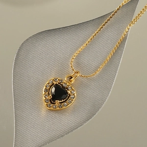 Elegant gold titanium steel necklace featuring a black heart pendant with zircon halo