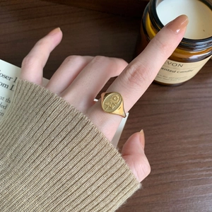 Close-up of gold sunflower signet ring in 925 sterling silver worn on finger