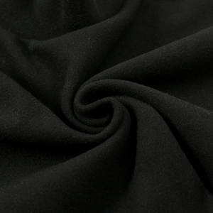 Macro shot of thick black velvet fabric detailing spiral pleats and soft fiber texture