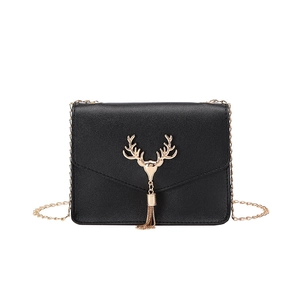 Chic black crossbody chain bag with a golden deer head tassel ornament on white background