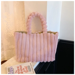 Detail of pink plush tote bag with vertical stripes texture and bubble handle design