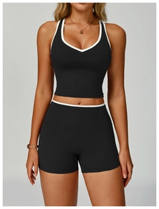 Dettaglio del set da yoga nero con bordi bianchi a contrasto su top a V e pantaloncini