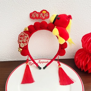 Detail of red Year of the Horse headband with golden ingots, plush horse and silk tassels
