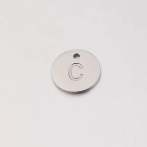 Detailed view of silver stainless steel 12mm round charm with engraved letter C