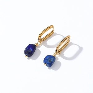 Detail view of gold hoop earrings with irregular blue natural stone pendant and textures