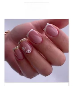 Detail of short square press-on nails with white flower art and French tips