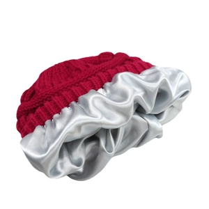 Detailed close-up of dark red winter beanie with smooth silver satin lining for hair care