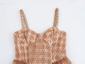 Dettaglio dell'abito con spalline a V, rose 3D e tessuto a rete a pois neri chic