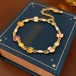 Détail d'un bracelet vintage en émail doré avec breloques coccinelles en boîte cadeau