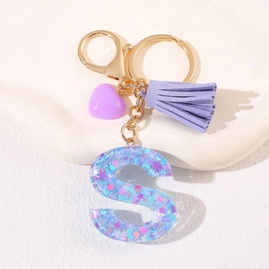 Close-up of letter S keychain with purple heart charm and gold-tone metal ring