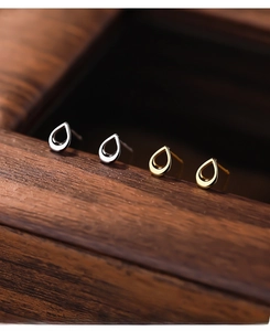 Macro shot of S999 silver teardrop hollow earrings in gold and silver finishes