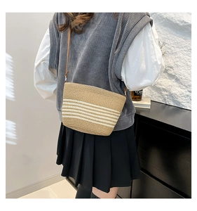 Close-up of khaki and white striped straw weave texture with slim brown strap