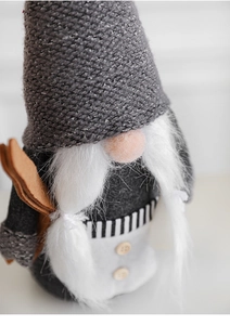 Détail du gnome de Noël avec bonnet en tricot gris, tresses blanches et bouton en bois