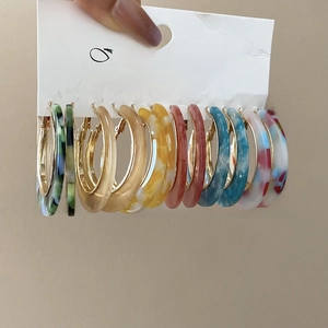 Close-up of 7 pairs of acetate leopard print C-shape hoop earrings on a display card