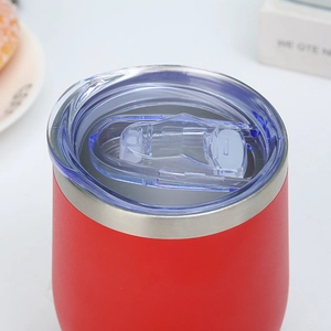Detail of transparent sliding lid and red matte stainless steel wine tumbler rim