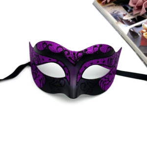 Detail shot of purple and black lace mask with gold glitter and floral vine patterns