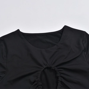 Dettaglio del girocollo e del design arricciato con ritaglio sull'abito nero a maniche lunghe