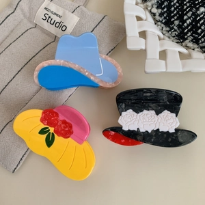 Three acetate hair claws in cowboy and floral sun hat designs for diverse hairstyles