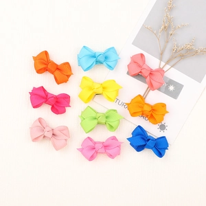 Flat lay of colorful 4cm grosgrain ribbon bow hair clips for girls on a white background