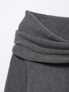 Detailed close-up of dark grey knitted fabric showing soft texture and off-shoulder neckline