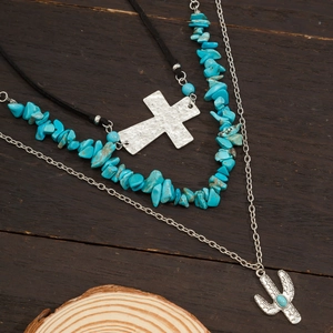 Detail of bohemian layered necklace set with turquoise beads, cactus and cross pendants