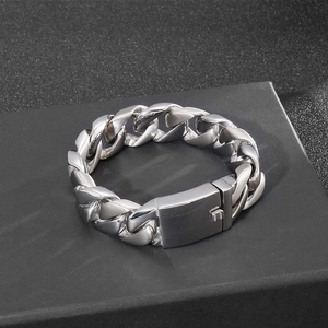 Polished silver Cuban link bracelet on matte black box with chunky industrial design