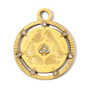 Macro shot of gold stainless steel circular pendant with butterfly and spade motifs