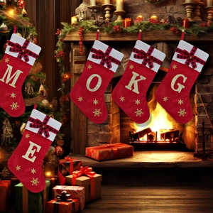 Detail of red velvet Christmas stockings with golden sequin letters and knit texture