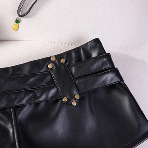 Detailansicht der schwarzen PU-Ledershorts mit Metallnieten und strukturierter Narbung