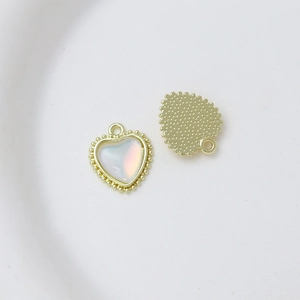 Detailed close-up of heart charm with gold beaded edge and iridescent inlay for DIY jewelry