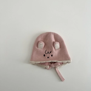 Close-up of pink knit baby hat with bear ears, cotton lining and chin straps