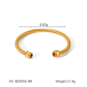 Macro detail of gold-plated twisted cable bracelet with tiger eye stones on both ends