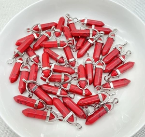 Detailed view of red hexagonal crystal pendants with black veins in a white bowl