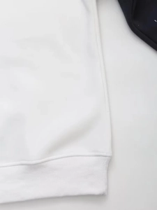 Detail of ribbed hem and precise stitching on white cotton blend casual sweatshirt