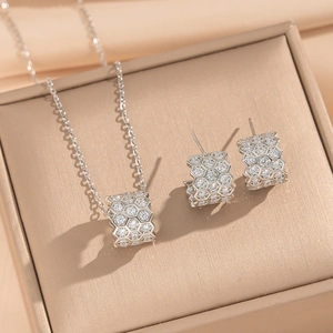 Silver honeycomb jewelry set with crystal pavé necklace and hoop earrings on a display box