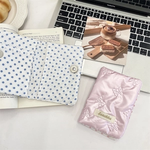 Detailed view of pink quilted PU passport cover with 3D bow and blue polka dot lining