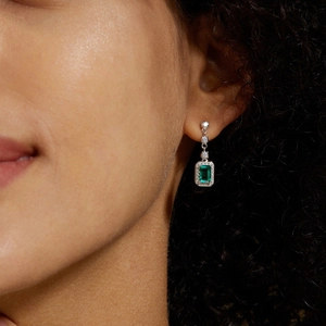 Eleganti orecchini pendenti in argento S925 smeraldo con incastonatura halo su modella