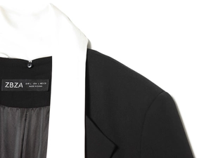 Détail du blazer noir avec revers blanc contrasté et texture de tissu tissé précise