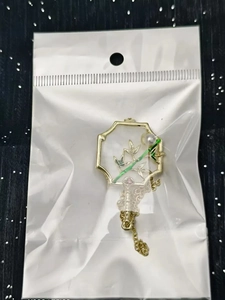 Detail of vintage gold bamboo brooch with pearl accent and elegant tassel chain