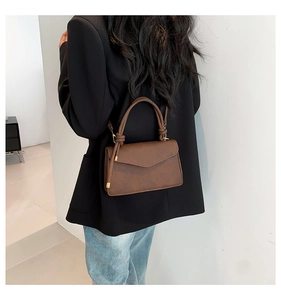 Sac bandoulière marron café avec poignée nouée porté par un mannequin