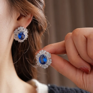 Vista ravvicinata di orecchini vintage in argento con gemma ovale blu e diamanti
