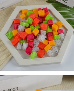 Macro shot of assorted artificial resin fruit cubes in a white tray for DIY decor