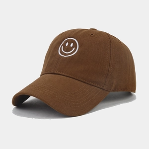 Detailed embroidery of a white smiley face on a caramel brown cotton baseball cap