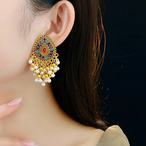 Détail de boucles d'oreilles vintage en forme de goutte avec cristaux et perles blanches