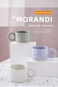 Close-up of Morandi ceramic mugs with ink splatter texture and large circular handles