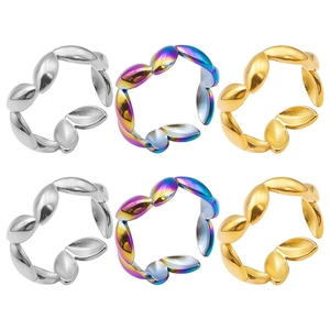 Macro detail of six adjustable leaf-shaped stainless steel rings in silver gold and rainbow