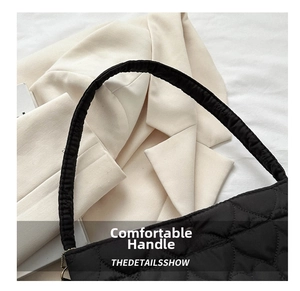 Close-up of padded top handles and diamond-quilted texture on black nylon bucket bag