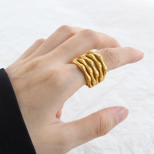 Close-up of golden multi-layered bamboo style hollow ring worn on person's finger