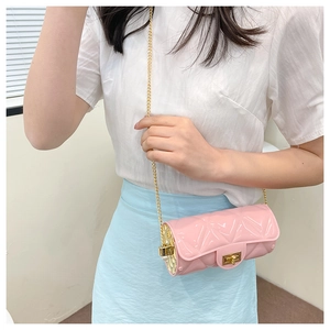 Pink quilted cylinder bag with gold chain strap shown on model with white shirt